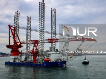 A high-horsepower tugboat pulls the fourth-generation offshore wind power construction platform ''Ganghangping 5'' off the Haixi Heavy Machi...