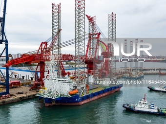 A high-horsepower tugboat pulls the fourth-generation offshore wind power construction platform ''Ganghangping 5'' off the Haixi Heavy Machi...