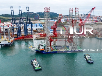 A high-horsepower tugboat pulls the fourth-generation offshore wind power construction platform ''Ganghangping 5'' off the Haixi Heavy Machi...