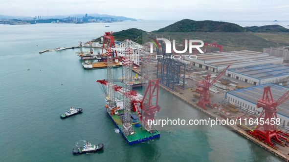 A high-horsepower tugboat pulls the fourth-generation offshore wind power construction platform ''Ganghangping 5'' off the Haixi Heavy Machi...