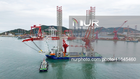 A high-horsepower tugboat pulls the fourth-generation offshore wind power construction platform ''Ganghangping 5'' off the Haixi Heavy Machi...