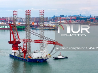 A high-horsepower tugboat pulls the fourth-generation offshore wind power construction platform ''Ganghangping 5'' off the Haixi Heavy Machi...