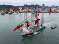 A high-horsepower tugboat pulls the fourth-generation offshore wind power construction platform ''Ganghangping 5'' off the Haixi Heavy Machi...