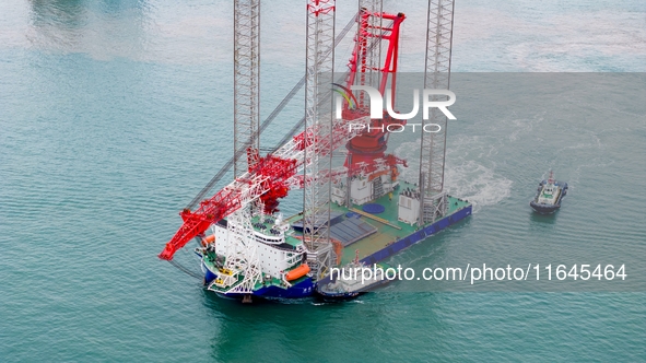 A high-horsepower tugboat pulls the fourth-generation offshore wind power construction platform ''Ganghangping 5'' off the Haixi Heavy Machi...