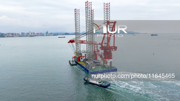 A high-horsepower tugboat pulls the fourth-generation offshore wind power construction platform ''Ganghangping 5'' off the Haixi Heavy Machi...