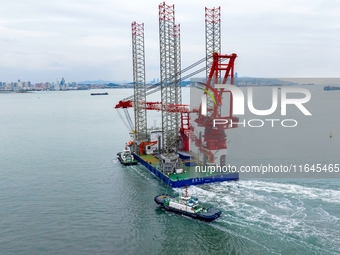 A high-horsepower tugboat pulls the fourth-generation offshore wind power construction platform ''Ganghangping 5'' off the Haixi Heavy Machi...