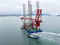 A high-horsepower tugboat pulls the fourth-generation offshore wind power construction platform ''Ganghangping 5'' off the Haixi Heavy Machi...