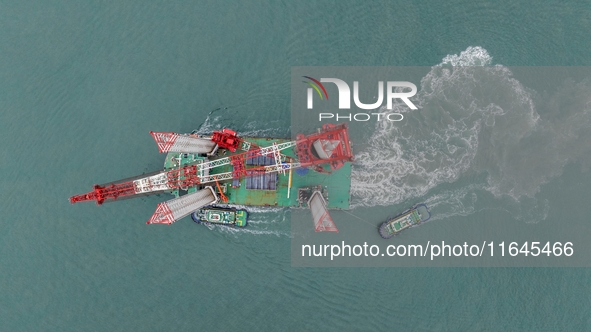 A high-horsepower tugboat pulls the fourth-generation offshore wind power construction platform ''Ganghangping 5'' off the Haixi Heavy Machi...