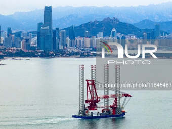 A high-horsepower tugboat pulls the fourth-generation offshore wind power construction platform ''Ganghangping 5'' off the Haixi Heavy Machi...