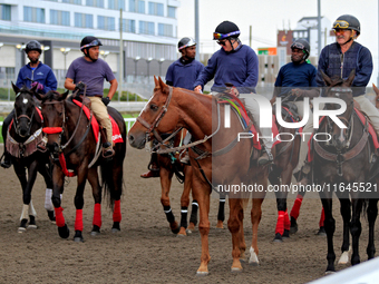 Outriders gather on the track after a race at Woodbine Racetrack in Toronto, Canada, on October 6, 2024. (