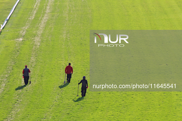 Track employees walk while inspecting and repairing the E.P. Taylor turf course ahead of a race at Woodbine Racetrack in Toronto, Canada, on...