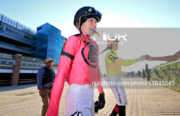 Jockey Sofia Vives walks to the walking ring while fellow jockey Ryan Munger receives a fist bump ahead of the 87th running of the $250,000...