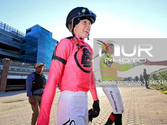 Jockey Sofia Vives walks to the walking ring while fellow jockey Ryan Munger receives a fist bump ahead of the 87th running of the $250,000...