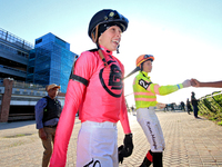 Jockey Sofia Vives walks to the walking ring while fellow jockey Ryan Munger receives a fist bump ahead of the 87th running of the $250,000...