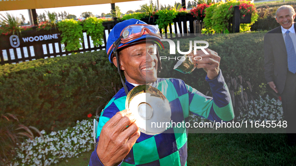 Jockey Patrick Husbands poses for photos after riding Scorching to a win in the 87th running of the $250,000 Cup & Saucer Stakes race at Woo...