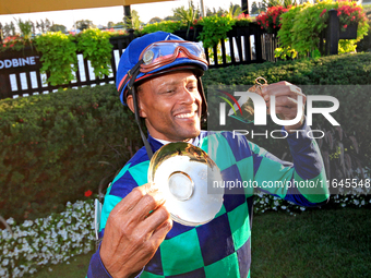 Jockey Patrick Husbands poses for photos after riding Scorching to a win in the 87th running of the $250,000 Cup & Saucer Stakes race at Woo...