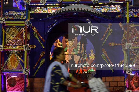 A lady rides past a Pandal on her bicycle during the Durga Puja festival in Kolkata, India, on October 6, 2024. 