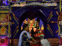 A lady rides past a Pandal on her bicycle during the Durga Puja festival in Kolkata, India, on October 6, 2024. (