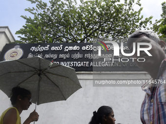 People walk in front of the Commission to Investigate Allegations of Bribery or Corruption office in Colombo, Sri Lanka, on October 4, 2024....