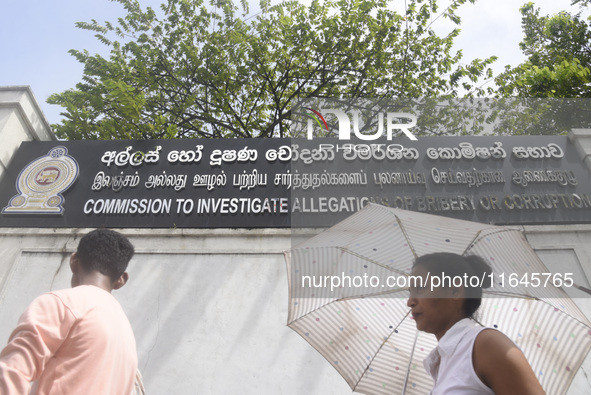 People walk in front of the Commission to Investigate Allegations of Bribery or Corruption office in Colombo, Sri Lanka, on October 4, 2024....