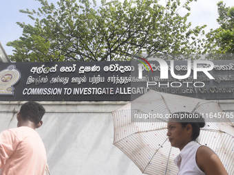 People walk in front of the Commission to Investigate Allegations of Bribery or Corruption office in Colombo, Sri Lanka, on October 4, 2024....