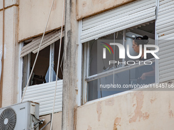 Residents and Israeli authorities inspect the damage following an overnight rocket attack from Lebanon in Haifa, Israel, on October 7, 2024....