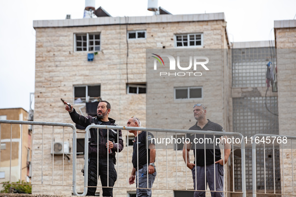 Residents and Israeli authorities inspect the damage following an overnight rocket attack from Lebanon in Haifa, Israel, on October 7, 2024....