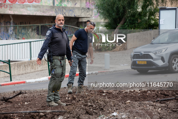 Residents and Israeli authorities inspect the damage following an overnight rocket attack from Lebanon in Haifa, Israel, on October 7, 2024....