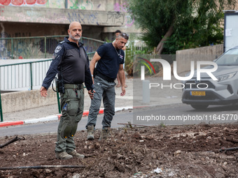 Residents and Israeli authorities inspect the damage following an overnight rocket attack from Lebanon in Haifa, Israel, on October 7, 2024....