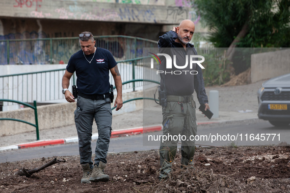 Residents and Israeli authorities inspect the damage following an overnight rocket attack from Lebanon in Haifa, Israel, on October 7, 2024....