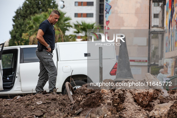 Residents and Israeli authorities inspect the damage following an overnight rocket attack from Lebanon in Haifa, Israel, on October 7, 2024....