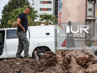 Residents and Israeli authorities inspect the damage following an overnight rocket attack from Lebanon in Haifa, Israel, on October 7, 2024....