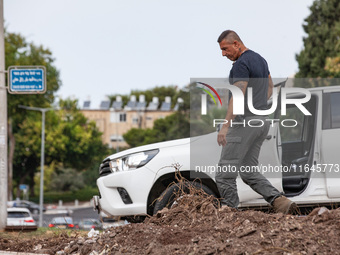 Residents and Israeli authorities inspect the damage following an overnight rocket attack from Lebanon in Haifa, Israel, on October 7, 2024....