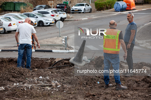 Residents and Israeli authorities inspect the damage following an overnight rocket attack from Lebanon in Haifa, Israel, on October 7, 2024....