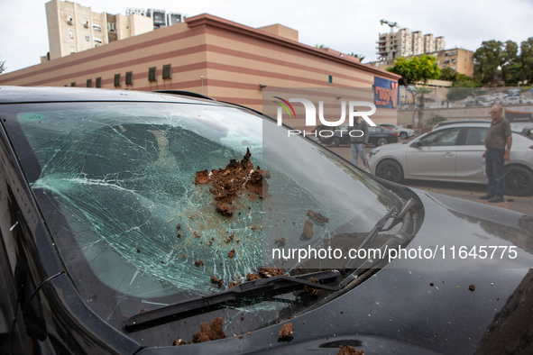 Residents and Israeli authorities inspect the damage following an overnight rocket attack from Lebanon in Haifa, Israel, on October 7, 2024....