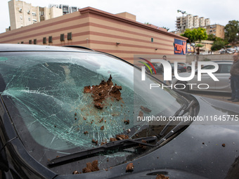 Residents and Israeli authorities inspect the damage following an overnight rocket attack from Lebanon in Haifa, Israel, on October 7, 2024....