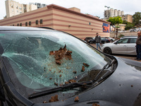 Residents and Israeli authorities inspect the damage following an overnight rocket attack from Lebanon in Haifa, Israel, on October 7, 2024....