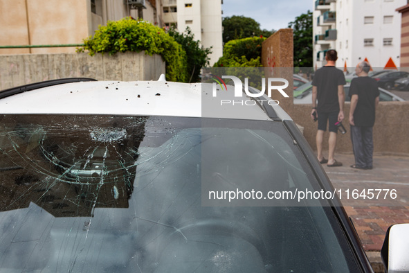 Residents and Israeli authorities inspect the damage following an overnight rocket attack from Lebanon in Haifa, Israel, on October 7, 2024....