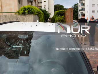 Residents and Israeli authorities inspect the damage following an overnight rocket attack from Lebanon in Haifa, Israel, on October 7, 2024....