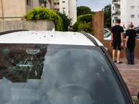 Residents and Israeli authorities inspect the damage following an overnight rocket attack from Lebanon in Haifa, Israel, on October 7, 2024....