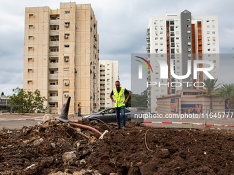 Residents and Israeli authorities inspect the damage following an overnight rocket attack from Lebanon in Haifa, Israel, on October 7, 2024....