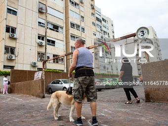 Residents and Israeli authorities inspect the damage following an overnight rocket attack from Lebanon in Haifa, Israel, on October 7, 2024....