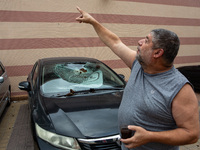 Residents and Israeli authorities inspect the damage following an overnight rocket attack from Lebanon in Haifa, Israel, on October 7, 2024....