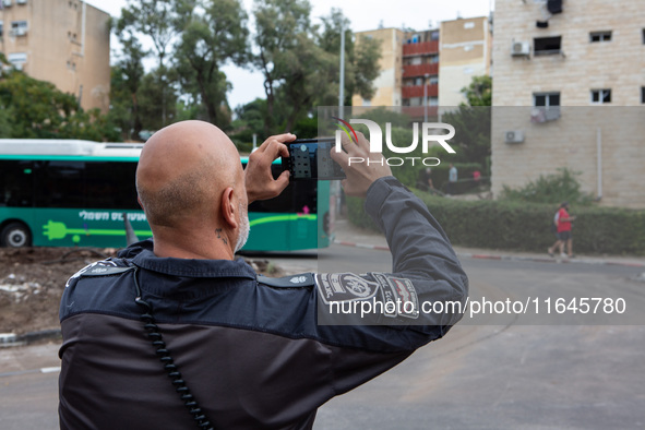 Residents and Israeli authorities inspect the damage following an overnight rocket attack from Lebanon in Haifa, Israel, on October 7, 2024....