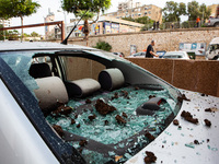 Residents and Israeli authorities inspect the damage following an overnight rocket attack from Lebanon in Haifa, Israel, on October 7, 2024....