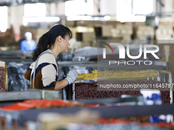 A worker produces pencils at the production workshop of China First Pencil Sihong Co., LTD in Sihong Economic Development Zone in Suqian, Ji...