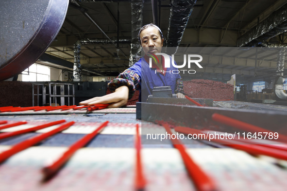 A worker produces pencils at the production workshop of China First Pencil Sihong Co., LTD in Sihong Economic Development Zone in Suqian, Ji...