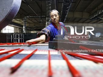 A worker produces pencils at the production workshop of China First Pencil Sihong Co., LTD in Sihong Economic Development Zone in Suqian, Ji...