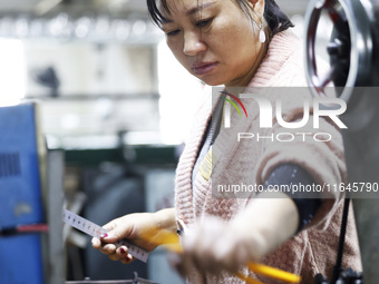 A worker produces pencils at the production workshop of China First Pencil Sihong Co., LTD in Sihong Economic Development Zone in Suqian, Ji...