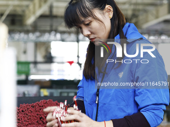 A worker produces pencils at the production workshop of China First Pencil Sihong Co., LTD in Sihong Economic Development Zone in Suqian, Ji...